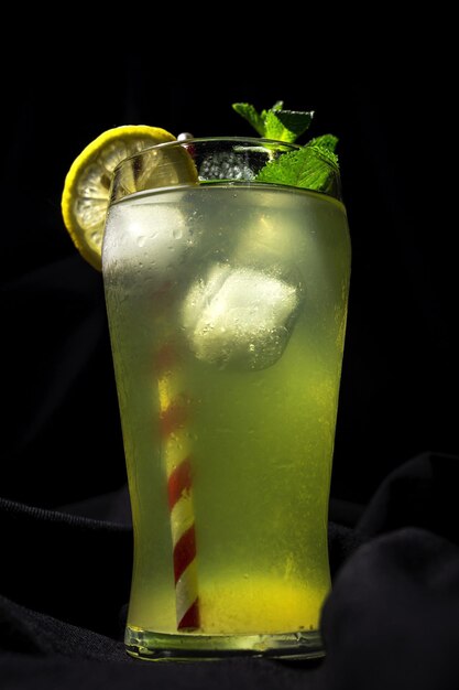 Limonada casera fresca o cóctel de mojito con menta de limón y hielo en un fondo oscuro