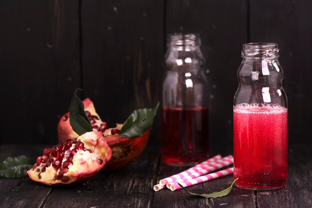 Limonada casera de granada roja en pequeñas botellas de vidrio