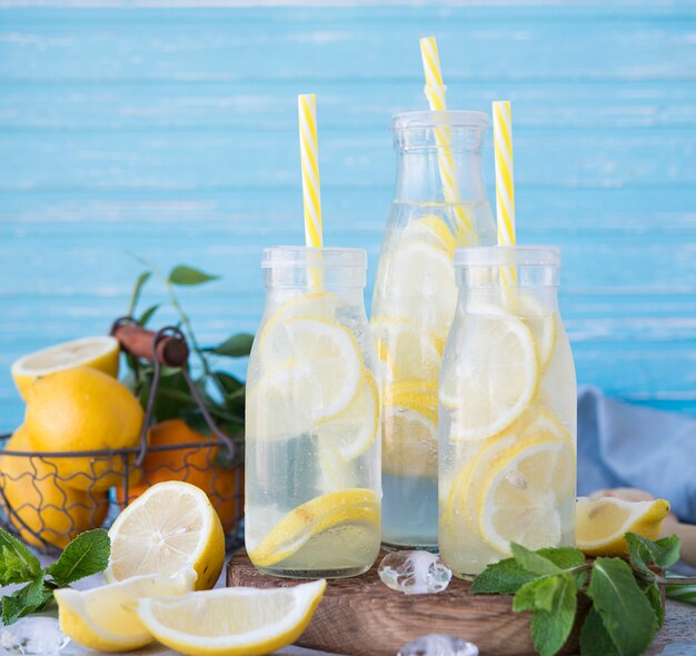 Limonada casera con limón, menta y hielo en botellas.