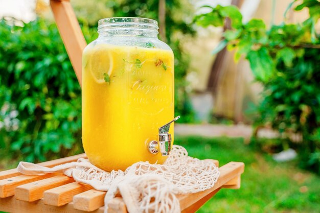 Foto limonada cítrica caseira em uma garrafa de vidro ao ar livre em um fundo de grama