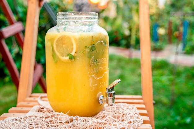 Limonada de cítricos casera en una jarra de vidrio fuera sobre un fondo de hierba