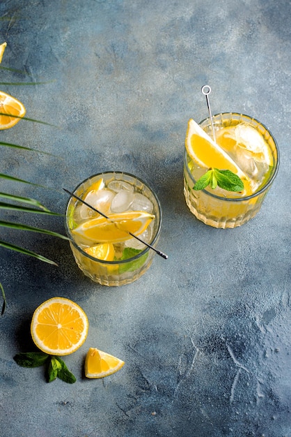 Limonada de cítricos con menta y limón en el vaso con cubitos de hielo