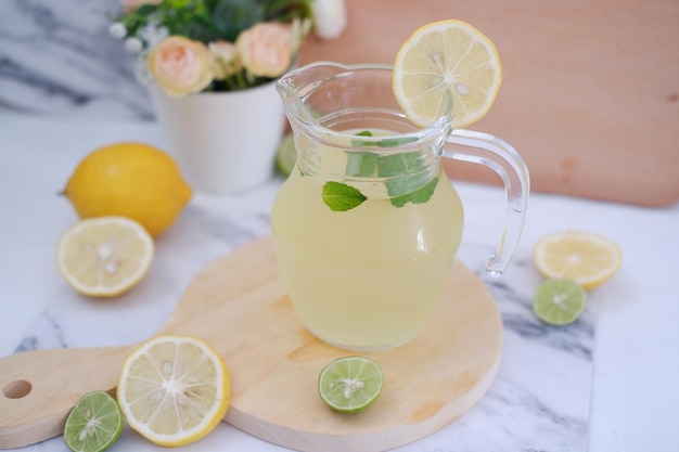 Foto limonada com folhas de limão e hortelã frescas sobre um fundo branco