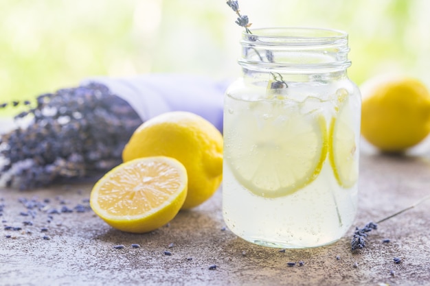 Limonada com limões e alfazema na mesa de pedra sobre a natureza