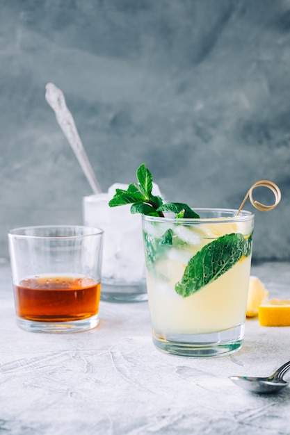 Limonada de gelo em copo com pedaços de limão, hortelã fresca e cubos de gelo