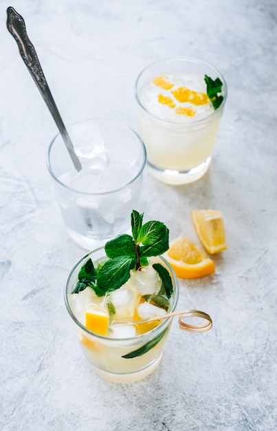 Limonada de gelo em copo com pedaços de limão, hortelã fresca e cubos de gelo