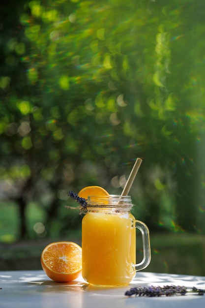 Limonada de laranja em uma caneca sobre a mesa no contexto da vegetação natural