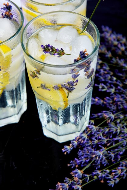 Limonada de lavanda com limão e gelo no preto.