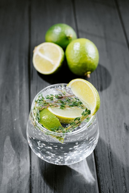 Limonada de limão com tomilho gengibre e gelo fundo escuro de madeira