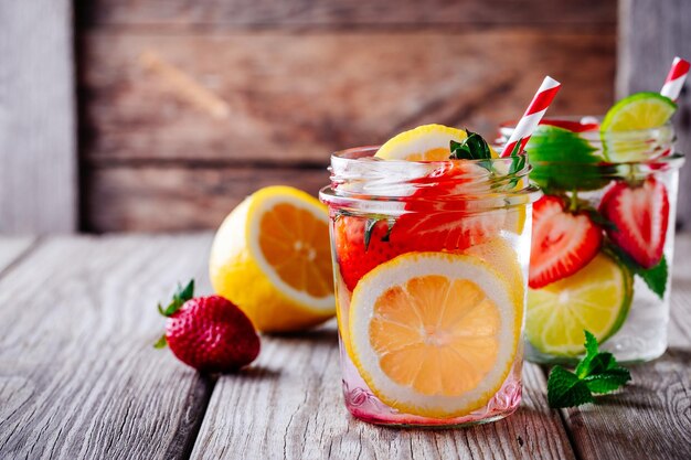 Limonada de limão e morango em frascos de vidro sobre fundo de madeira Uma bebida refrescante de verão