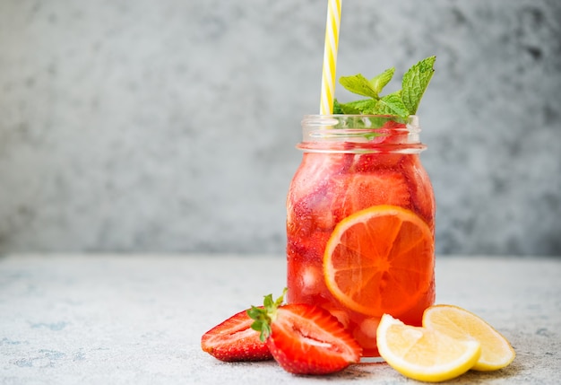 Limonada de morango caseira com gelo em uma jarra, coquetel frio de verão, foco seletivo, espaço de cópia