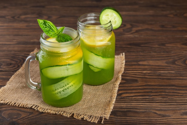 Limonada de pepino com manjericão e limão sobre uma mesa de madeira