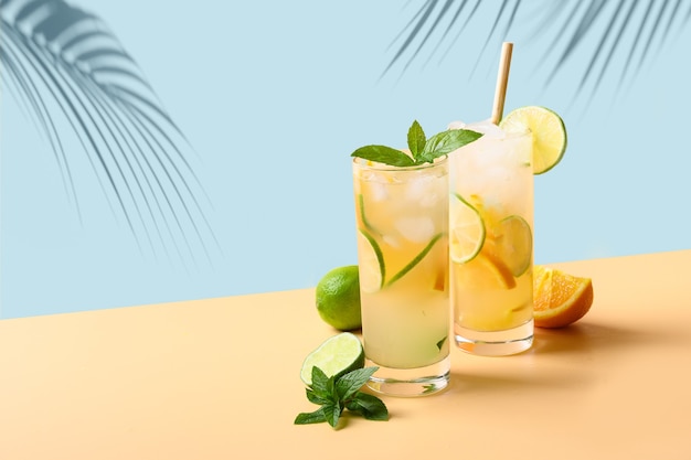 Limonada de verão ou coquetel com fatia de laranja e limão na cor de fundo. bebida refrescante