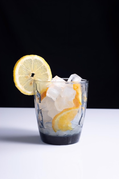 Limonada em um copo com um canudo em uma mesa branca e fundo preto Minimalista