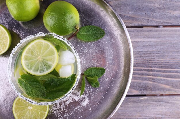 Foto limonada em vidro na bandeja com fundo de madeira