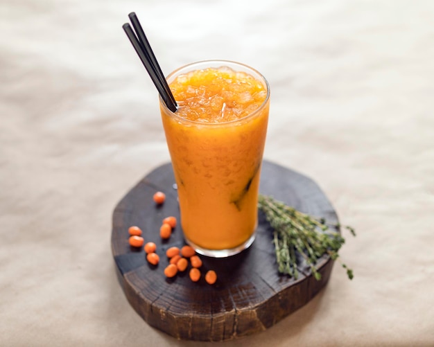 Limonada de espino amarillo sobre un soporte de madera en un vaso de vidrio