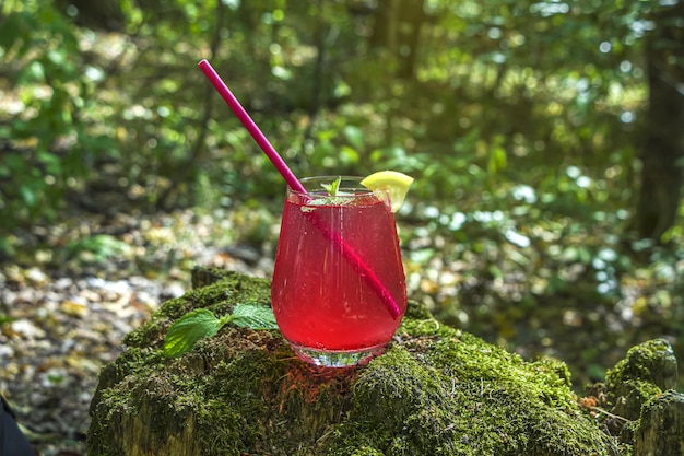 Limonada de fresa, bebida cóctel rosa sobre madera con musgo