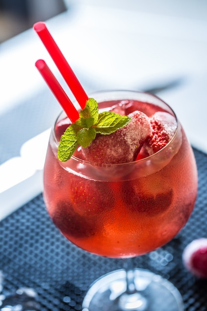 Limonada de fresa o cóctel alcohólico con sirope de hielo y hojas de menta en la mesa de la barra.