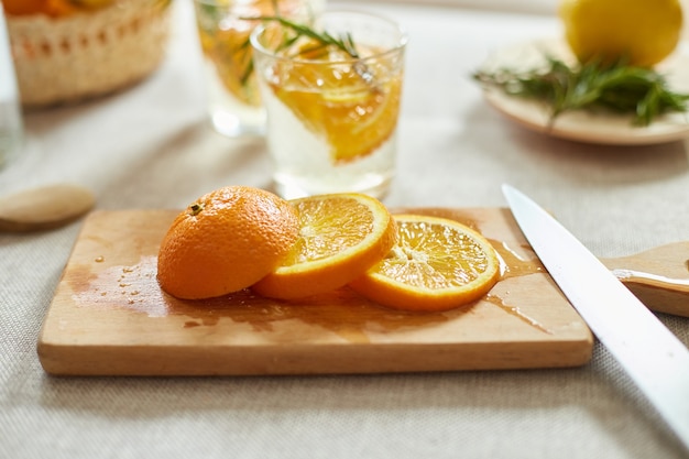 Limonada fresca de cítricos y romero en vaso sobre una mesa blanca en casa, bebida de verano, desintoxicación de agua saludable.