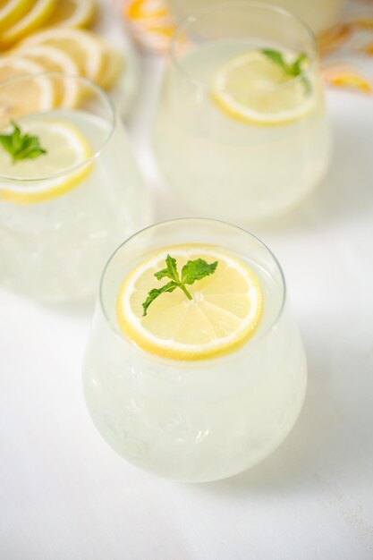 Limonada fresca em copos guarnecidos com fatias de limão e hortelã.