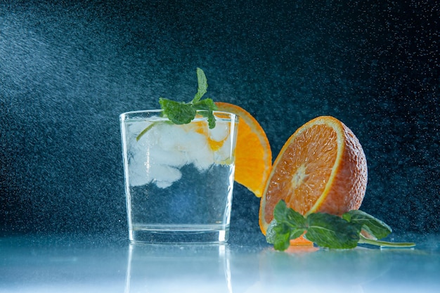 Limonada fresca con naranja menta y hielo en un frasco de vidrio sobre un fondo azul oscuro Salpicaduras de agua Salpicaduras Bebida fría de verano y cóctel