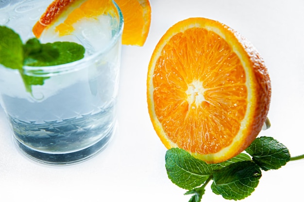 Limonada fresca con naranja menta y hielo en frasco de vidrio sobre el fondo claro Bebida fría de verano y cóctel