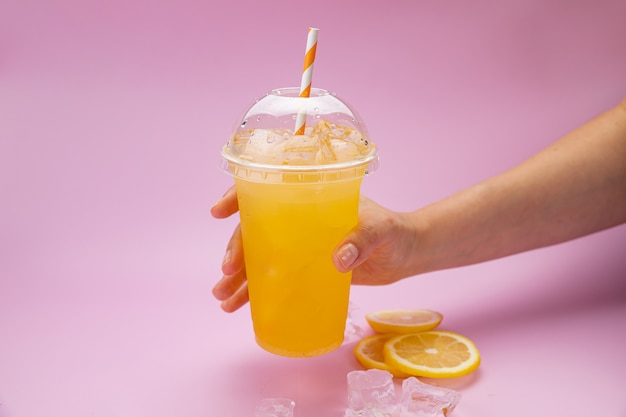 Limonada fresca con naranjas en un vaso de plástico