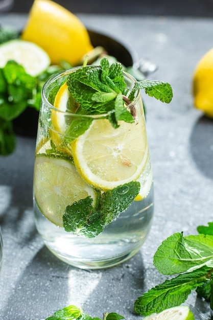 Limonada fría con menta, limón y lima en un vaso. preparación de limonada