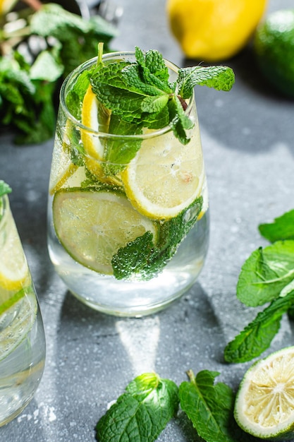 Limonada fría con menta, limón y lima en un vaso. preparación de limonada