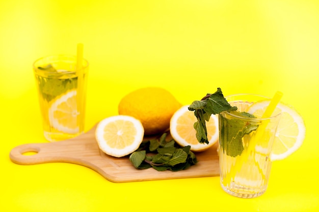 Limonada fría y sabrosa hecha de limones orgánicos y frescos sobre fondo amarillo
