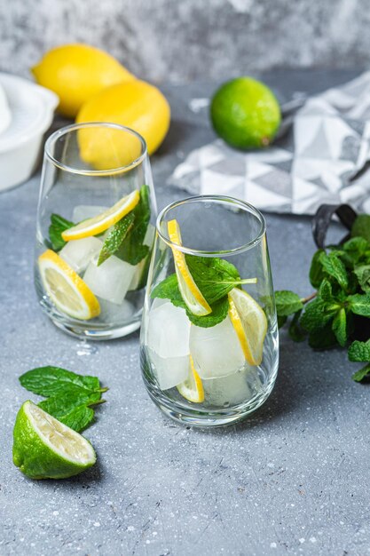 Limonada gelada com hortelã, limão e lima em um copo. Preparação de limonada