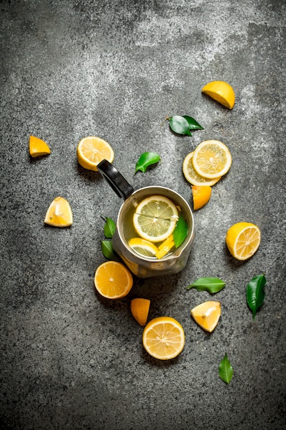 Limonada gelada em uma jarra com rodelas de limão e folhas verdes.