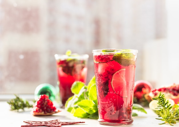 Limonada con granada y lima en vaso al sol con sombra