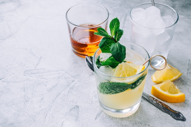 Limonada de hielo en vaso con trozos de limón, menta fresca y cubitos de hielo