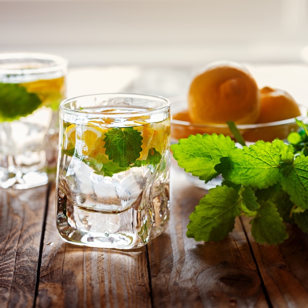 Limonada con limón fresco con azúcar y menta sobre fondo de madera