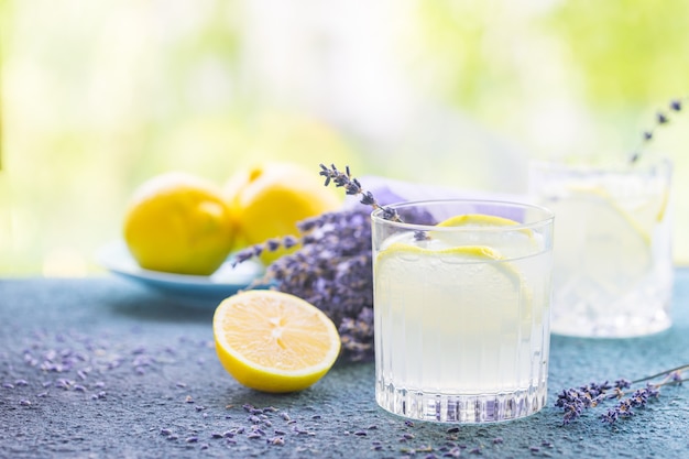 Limonada con limones y lavanda en mesa de piedra sobre la naturaleza