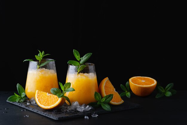 Limonada de naranja de verano frío con menta y hielo en un vaso Copiar espacio para texto