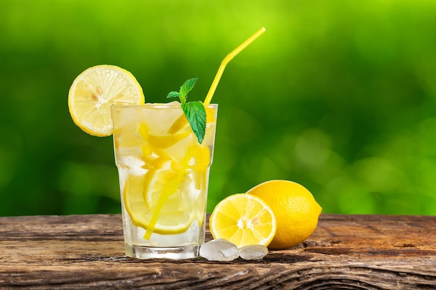 Limonada natural con menta y fruta fresca sobre mesa de madera