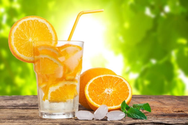 Limonada natural con menta y naranjas frescas sobre mesa de madera