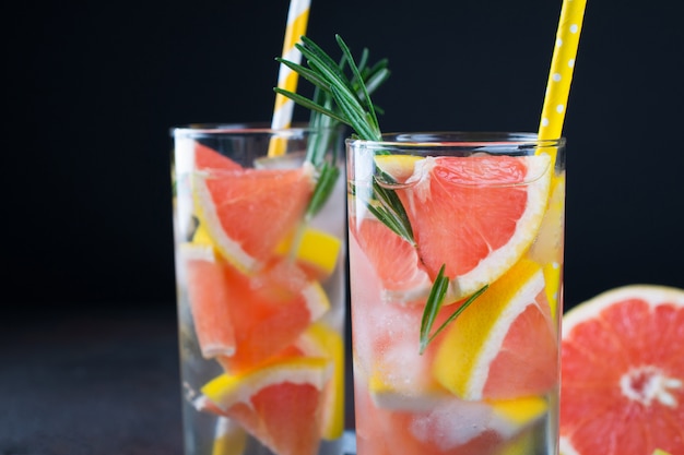 Limonada de pomelo. Dos vasos de bebida refrescante, agua con pomelo, ramas de romero y hielo. Concepto de receta, cóctel