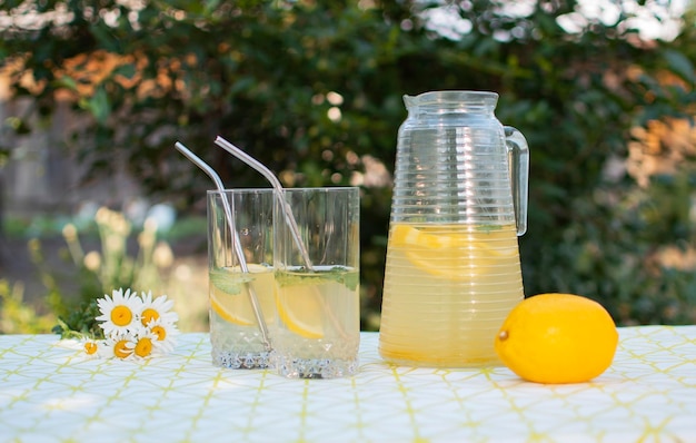 Limonada preparada na hora e frutas na mesa ao ar livre Bebida refrescante de verão Preparação de bebida de limonada