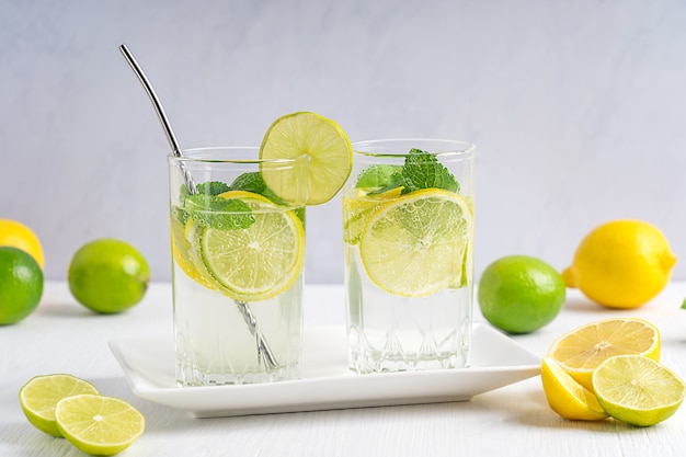 Limonada refrescante bebida de verão feita de rodelas de limão e lima e água com gás servida em copos