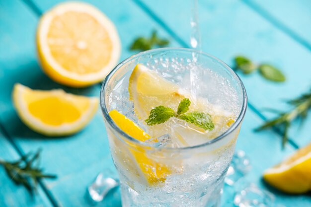 Limonada refrescante em vidro com limão na mesa de madeira