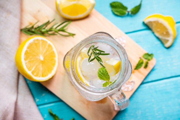 Limonada refrescante em vidro com limão na mesa de madeira