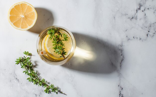 Limonada refrescante con una rodaja de limón y sombras duras de paja