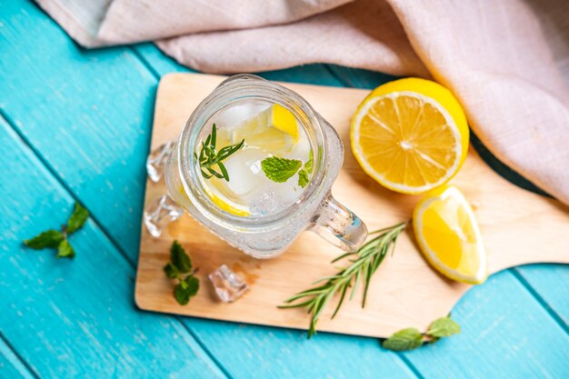 Limonada refrescante en vaso con limón en la mesa de madera