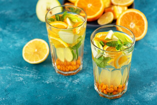 Limonada refrescante de verano con naranja, limón, menta en vasos