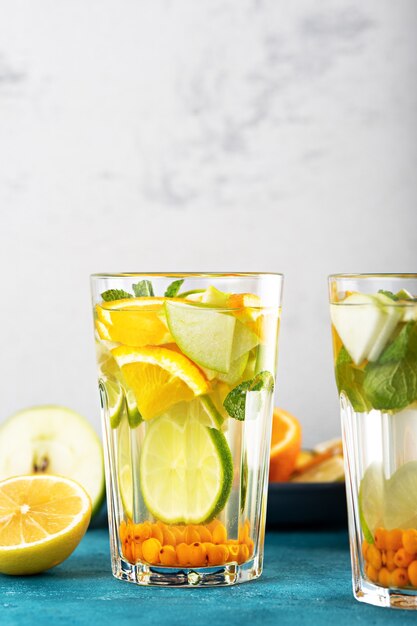 Limonada refrescante de verano con naranja, limón, menta en vasos