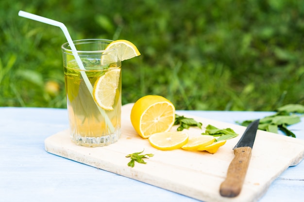 Limonada en vaso y limones en rodajas con menta