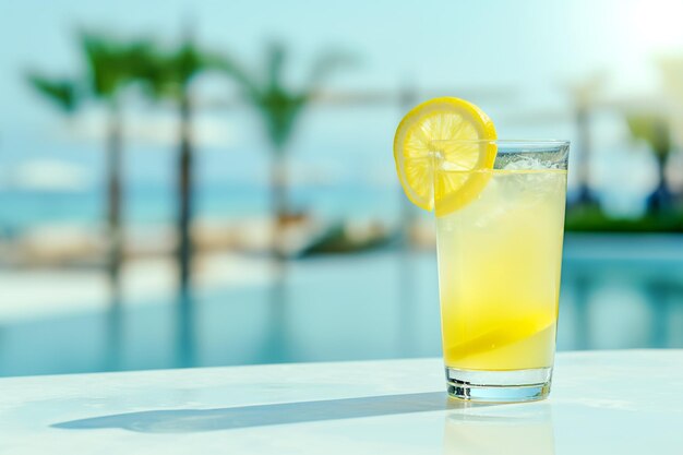 Limonada en un vaso sobre una superficie de hormigón blanco contra el fondo de un hotel tropical de lujo